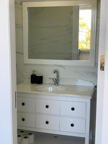 a bathroom with a white sink and a mirror at Maya New Guest House -Panoramic Sea&CityCentre View, Haifa in Haifa