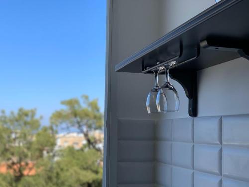 a kitchenaucet with two wine glasses hanging from it at Maya New Guest House -Panoramic Sea&CityCentre View, Haifa in Haifa