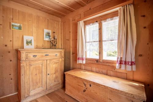 Habitación con banco y ventana en una cabaña de madera en Chalet Büdemji by Arosa Holiday, en Arosa