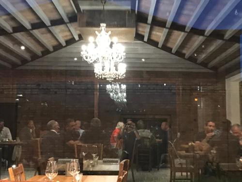 a group of people in a dining room with a chandelier at La Locanda Paradiso in SantʼEgidio