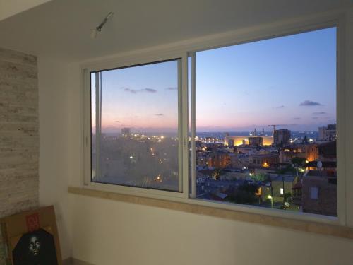 a window with a view of a city at Maya New Guest House -Panoramic Sea&CityCentre View, Haifa in Haifa