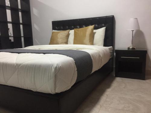 a black bed with white sheets and pillows on it at Tunaib Plaza in Aţ Ţunayb