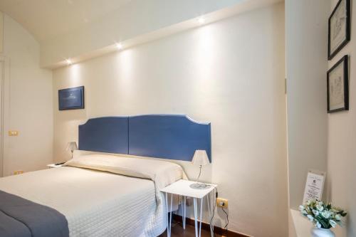 a bedroom with a bed with a blue headboard at B&B Quattro Cantoni in Siena