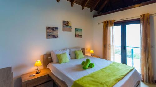a bedroom with a large bed with green pillows on it at Dream Villa Flamands 743 in Saint Barthelemy