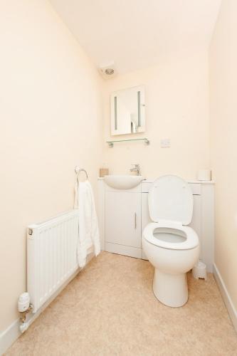 a white bathroom with a toilet and a sink at Callander Hostel in Callander