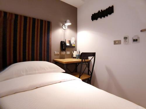 a bedroom with a bed and a small desk at River inn Station in Kaohsiung