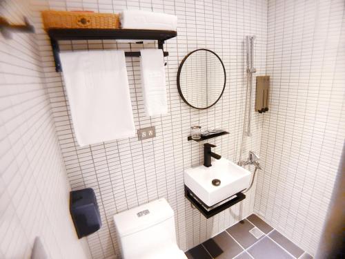 a white bathroom with a sink and a toilet at River inn Station in Kaohsiung