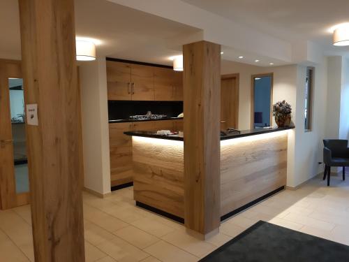 a kitchen with wooden cabinets and a counter top at Rossano Boutique Hotel & Ristorante in Ansbach