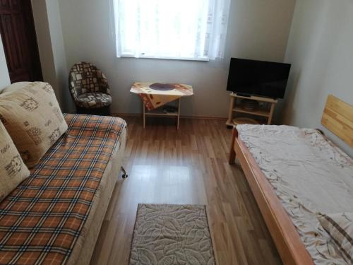Kleines Zimmer mit einem Bett und einem TV in der Unterkunft MIWA - pokoje do wynajęcia in Mikołajki