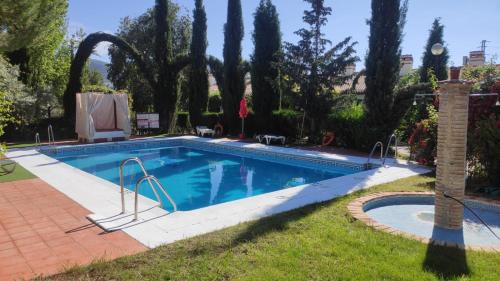 una piscina in un cortile alberato di Hotel Rural Puerto Mágina a Torres