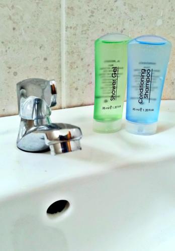 two bottles of soap sitting on a bathroom sink at MARI Residence in Kuala Terengganu