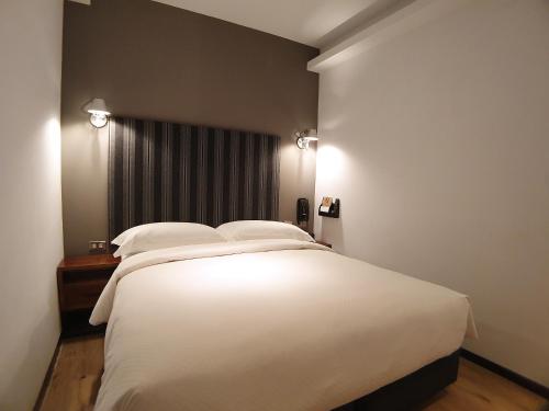 a bedroom with a large white bed with two pillows at River inn Station in Kaohsiung