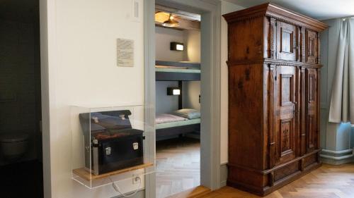 a room with a large wooden cabinet and a bedroom at Schloss Burgdorf Youth Hostel in Burgdorf