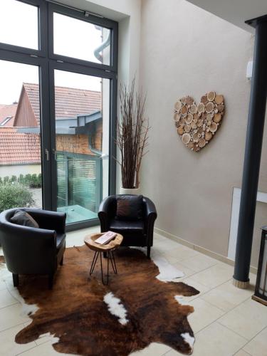 a living room with two chairs and a table at Rossano Boutique Hotel & Ristorante in Ansbach