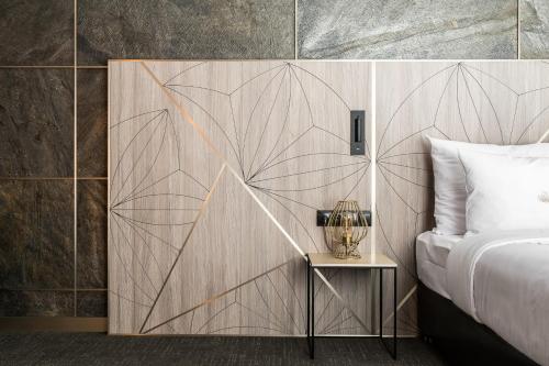 a bedroom with a wall with a design on it at Nosalowy Park Hotel & Spa in Zakopane