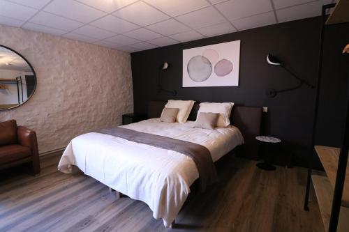 a bedroom with a large bed and a mirror at La Vieille Ferme Chassepierre in Chassepierre