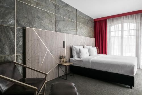 a bedroom with a bed and a red wall at Nosalowy Park Hotel & Spa in Zakopane