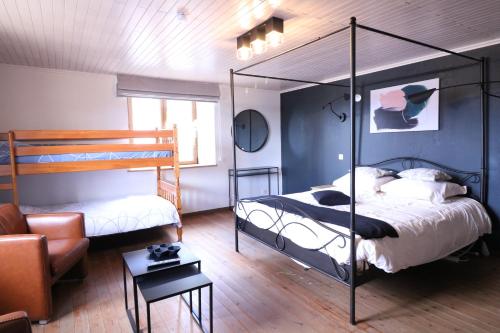 a bedroom with two bunk beds and a couch at La Vieille Ferme Chassepierre in Chassepierre