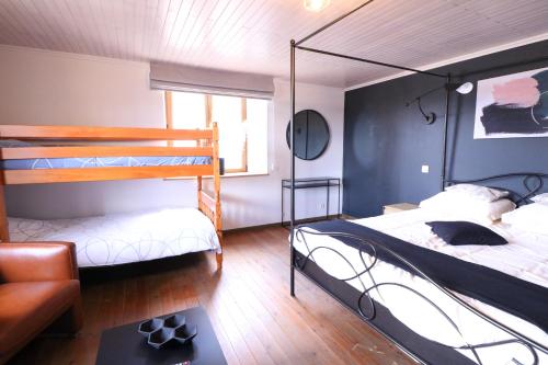 a bedroom with two bunk beds and a couch at La Vieille Ferme Chassepierre in Chassepierre