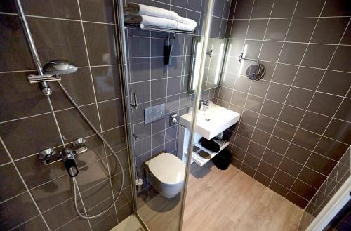 een badkamer met een douche, een toilet en een wastafel bij Kyriad Hotel Brest in Brest