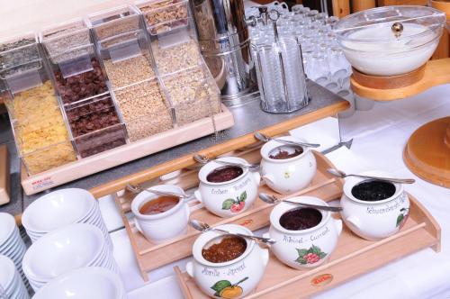 a table with bowls of food and spoons at Sieglhub Chalets - Appartements - Hotel in Flachau
