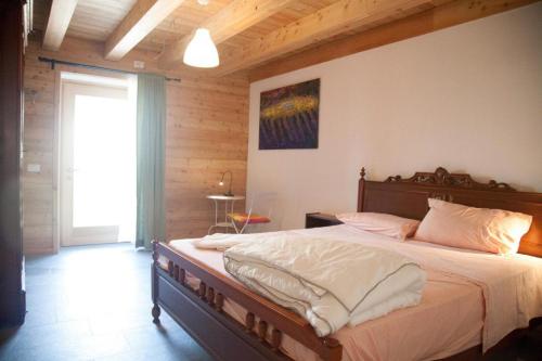 a bedroom with a large bed with a wooden ceiling at Agriturismo Athabaska in San Lorenzo in Banale