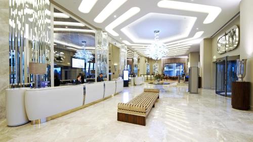 a lobby with a waiting area with benches and chandeliers at Crowne Plaza Bursa Convention Center & Thermal Spa by IHG in Bursa