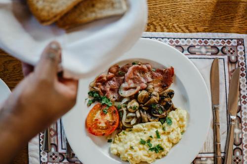 a plate of food with eggs mushrooms and bacon at Wendy's Country Lodge in Mtubatuba