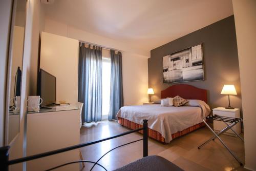 um quarto de hotel com uma cama e uma televisão em B&B Porta di Ponte em Agrigento