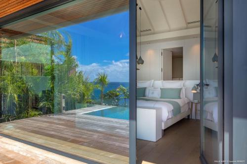 a bedroom in a villa with a view of the ocean at Dream Villa Corossol 776 in Saint Barthelemy