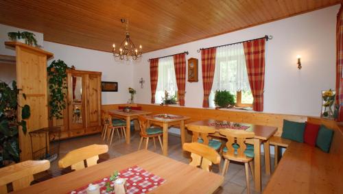 a restaurant with wooden tables and chairs and windows at Landhaus Schwaighofer Dachstein West in Russbach am Pass Gschütt