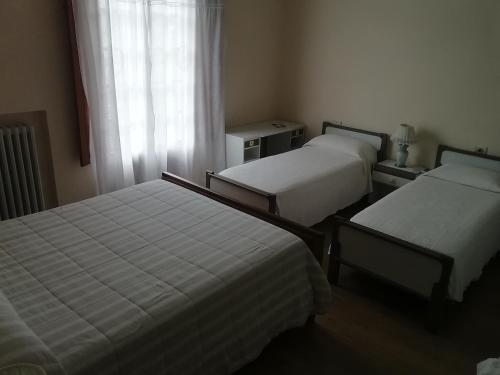 a hotel room with two beds and a window at La collina degli olivi in Carmignano