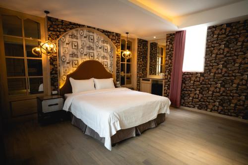 a bedroom with a large bed and a stone wall at 浪琴Motel文創旅館 in Taichung