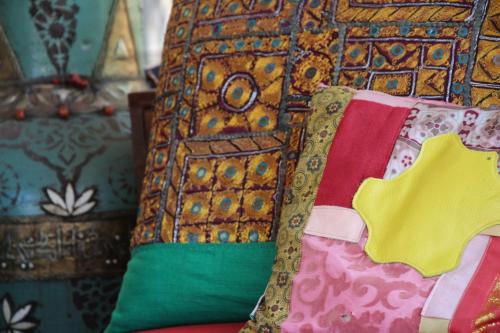 ランアーケンにあるDe Tuinkamer, Charme Logie & Table d’Hoteのベッドに座るカラフルな枕