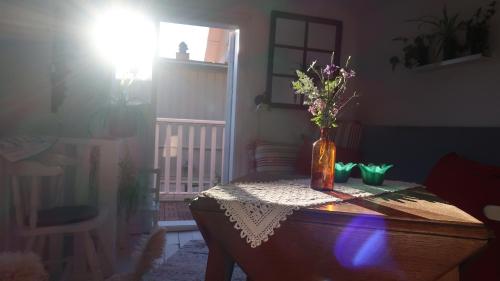 a vase with flowers on a table in a room at Pinglans bakficka in Gränna