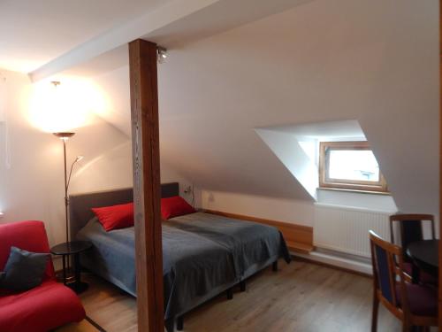 a attic bedroom with a bed and a window at ROKO Apartments in Kaunas