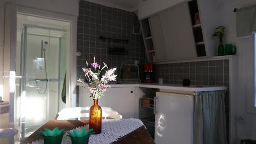 a vase with flowers on a table in a kitchen at Pinglans bakficka in Gränna
