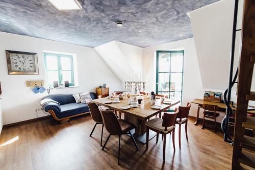 Müllner-Hof في Schwarzach bei Nabburg: غرفة طعام مع طاولة وكراسي وأريكة