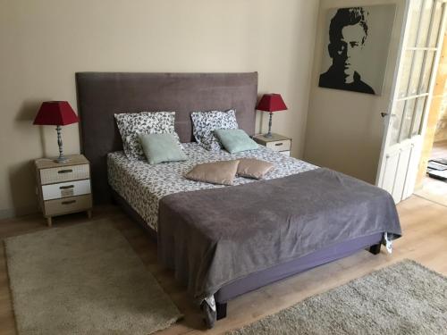 une chambre avec un grand lit avec deux tables de nuit dans l'établissement Un jardin en ville, à Sarlat-la-Canéda