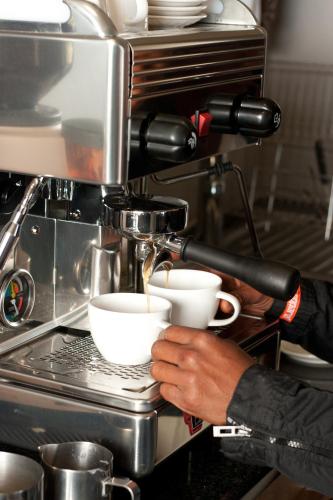 a person is pouring coffee into a cup at Cliff Lodge in Gansbaai