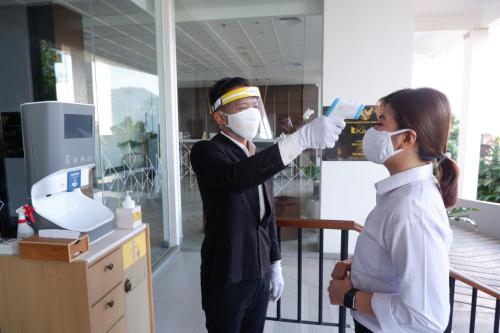 a man and a woman in a laboratory wearing masks at Kampi Hotel Tunjungan - Surabaya in Surabaya