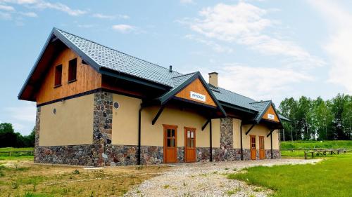 a building with a black roof on a field at Camping Bartbo in Olsztyn
