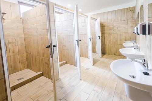 a bathroom with three sinks and a shower at Camping Bartbo in Olsztyn