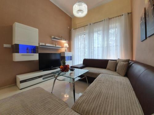 a living room with a couch and a tv at DWIE SOSNY Apartamenty przy plaży - SAUNA, JACUZZI, SIŁOWNIA, BAWIALNIA - 365PAM in Ustronie Morskie