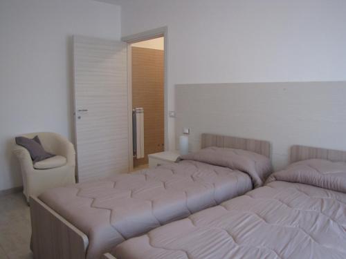 a bedroom with two beds and a chair in it at Quattro stagioni in Padula