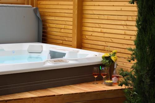 a jacuzzi tub with two glasses of wine at B&B Villa Pelèr in Lazise