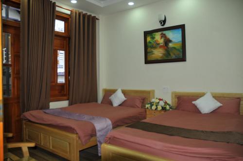 1 dormitorio con 2 camas y una foto en la pared en Anh Trang Homestay en Dalat