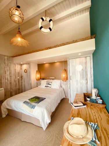 a bedroom with a large white bed and a blue wall at Hôtel Île de Lumière in La Cotinière
