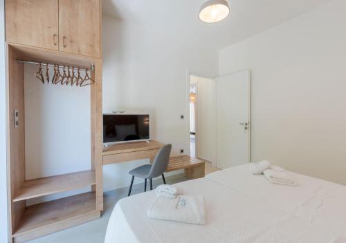 a bedroom with two beds and a desk and a chair at COSTA VASIA Seaside Suites and Apartments in Vrahati