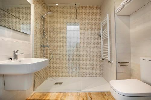 uma casa de banho com um chuveiro, um lavatório e um WC. em Apartamentos Salitre em Soto de la Marina